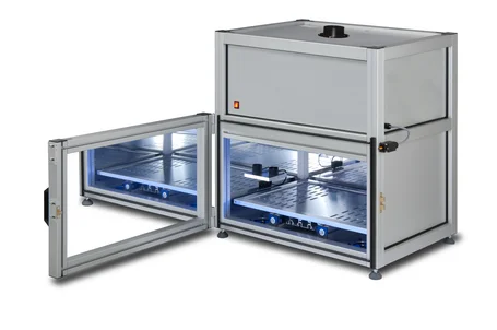 Linea di produzione con unità UV: stampa digitale UV con un'immagine appena polimerizzata a sinistra, moduli LED UV sopra pannelli di vetro al centro, rivestimento di un componente di carrozzeria a destra – l'UV come strumento