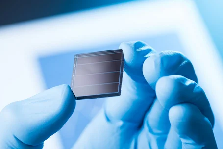 Simulatore solare con diversi corpi lampada che illuminano un modulo fotovoltaico, accanto un monitor che mostra la curva spettrale – simulatori solari nel fotovoltaico