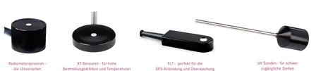 Diverse versioni di sensori UV con cavi e una testa di misura su un banco da laboratorio, dietro un monitor che mostra le curve di responsività UV-A, UV-B e UV-C e uno strumento di misura portatile – selezione di sensori UV